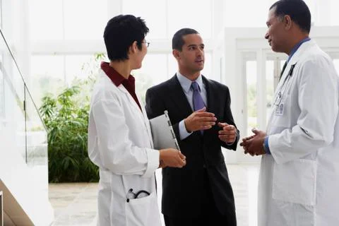 Doctors talking to businessman Stock Photos