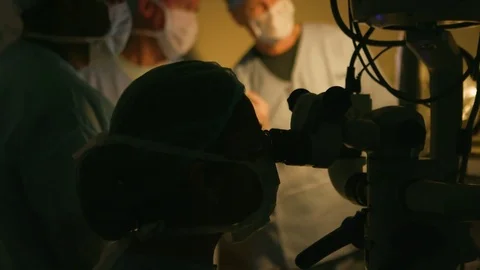 Doctor's team discussing in a semi-lit operating room Stock Footage 77447270