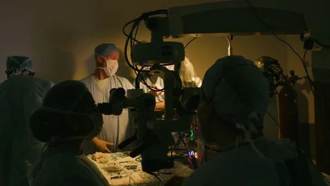 Doctor's team discussing in a semi-lit operating room Stock Footage 77482990