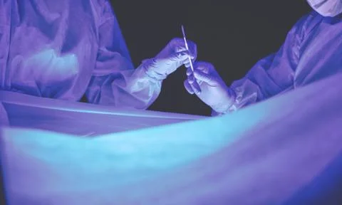 Doctors team in surgery in a dark background. Stock Photos