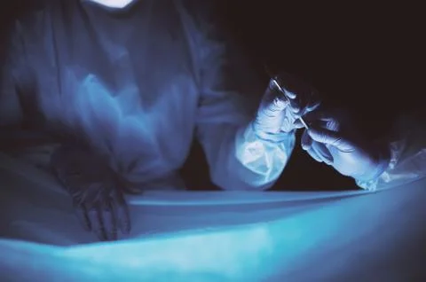 Doctors team in surgery in a dark background. Stock Photos