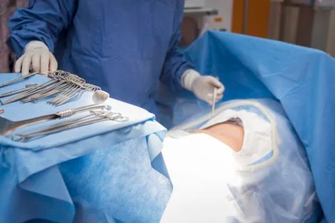 Doctors with tools in hands making surgery in operation room. Health care and Stock Photos