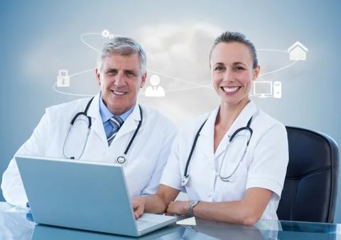 Doctors using laptop at desk against digitally generated background Foto stock