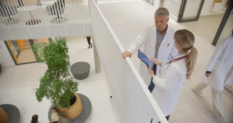 Doctors Using Tablet in Hospital Lobby Stock Footage 296189399