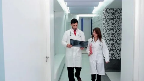  Doctors Walking and looking an xray  스톡 동영상 210670577