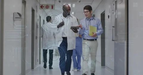 Doctors walking hospital hall comparing metrics tapping tablet, live streams Stock Footage 318238529