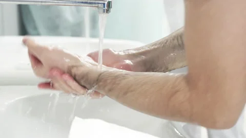 Doctors wash their hands under water and soap before undergoing surgery  Stock Footage 155979870