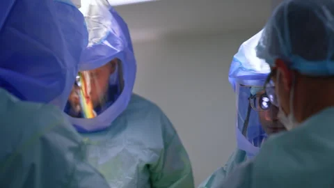 Doctors wearing protective helmets work together in a team at operation.  Stock Footage 263068864