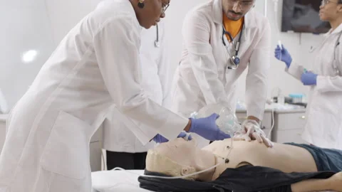 Doctors in white lab coats and blue gloves performing first aid on dummy Stock-Footage 270175262