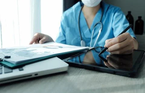 Doctor's working on laptop computer, writing prescription clipboard with re.. Stock Photos
