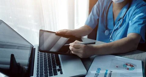 Doctor's working on laptop computer, writing prescription clipboard with re.. Foto stock