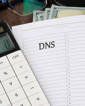 Document Highlighting DNS Abbreviation With Calculator and Cash on Table Du.. Stock Photos