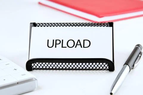 A document holder prominently displays an upload sign on a clean desk. Nearby Stock Photos