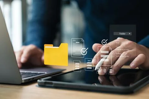 Document management system, DMS, company employees manage folders via laptop. Stock Photos