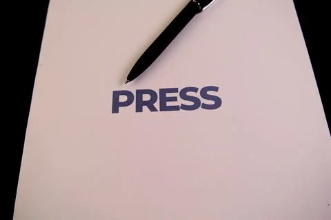 Document with press written in bold and a pen resting nearby Stock Photos