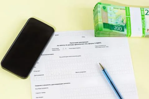 Document in Russian "Tax Declaration on personal income tax", pen, smartphone Stock Photos