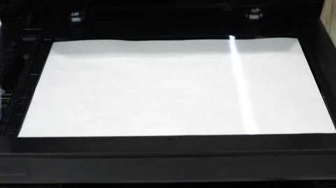 Document scanning process. Scanner in operation scans a sheet of paper with the 库存照片