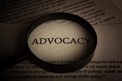 Document with the title of advocacy under a magnifying glass Stock Photos