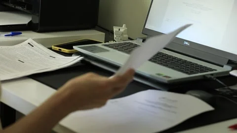 Documentation being checked at desk. Working to bring home salary. Slow Stock Footage 250512348