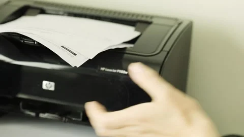 Documentation being printed and fed onto tray for collection by hand Stock Footage 250512369