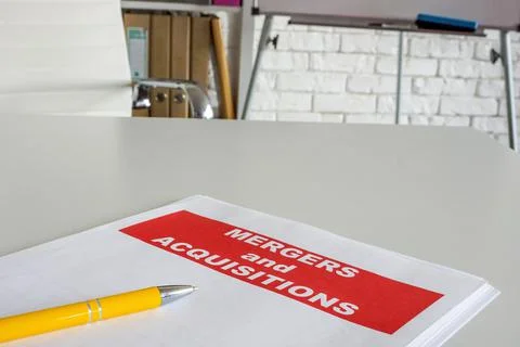 Documents about merger and acquisition on the office desk. Stock Photos