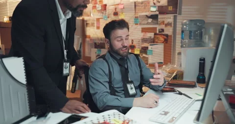 Documents, computer and detectives in office with discussion for solving case in Stock Footage 314792958