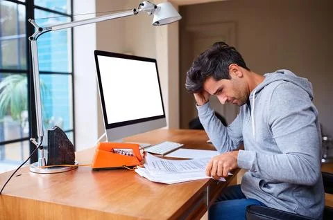 Documents, computer screen and man in home with stress for mistake on budge.. Stock Photos