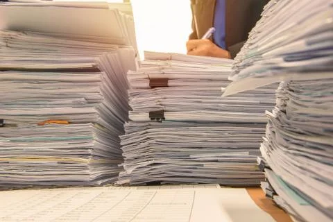 Documents on desk stack up high waiting to be managed Stock Photos