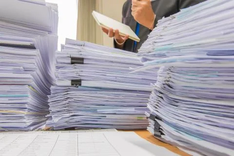 Documents on desk stack up high waiting to be managed Stock Photos