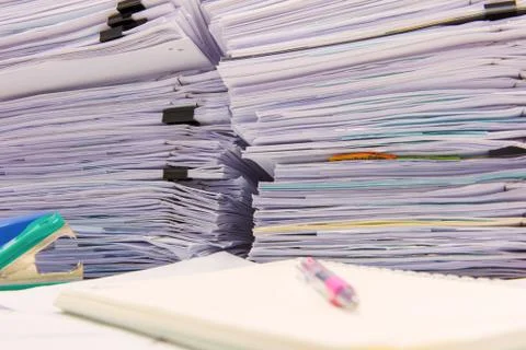 Documents on desk stack up high waiting to be managed Stock Photos