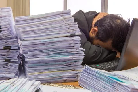 Documents on desk stack up high waiting to be managed 스톡 사진