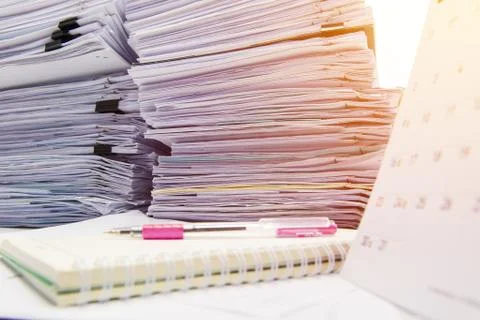 Documents on desk stack up high waiting to be managed Stock Photos