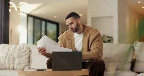 Documents, finance and laptop with man on sofa in home living room for budget or Stock Footage 335266520