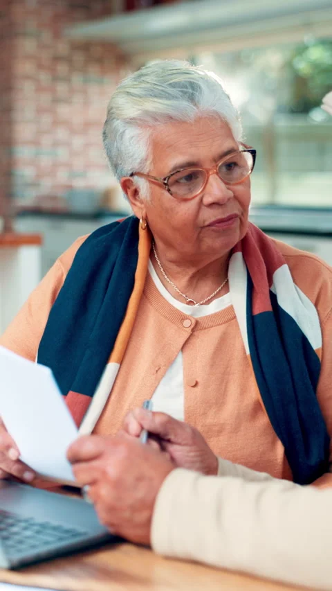Documents, finance and laptop with old woman at table in home for accounting or Stock Footage 321457169