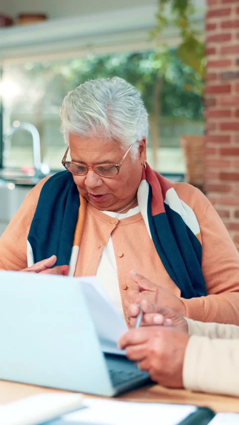 Documents, finance and laptop with old woman at table in home for accounting or Stock Footage 321739715
