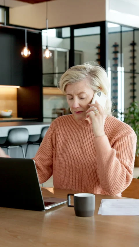 Documents, finance and phone call with old woman at desk in home for budget or Stock Footage 337479242