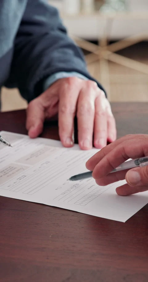 Documents, hands and signature of old person in home for insurance or investment 库存影片 338426710