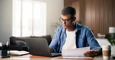 Documents, laptop and remote work with man in home study for planning, rese.. Stock Photos
