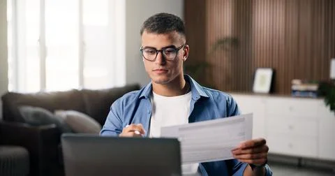 Documents, laptop and remote work with man in home office for planning, res.. Stock Photos