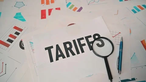Documents related to tariffs are placed on a table filled with charts and graphs Stock-Footage 338188324
