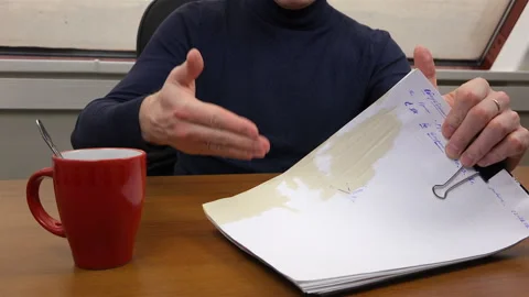 Documents soiled with spilled drink from a cup Stock-Footage 99998018