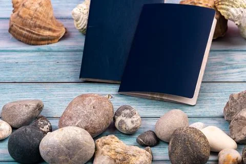 Documents, stones and shells on a blue wooden background.Travel theme Stock Photos