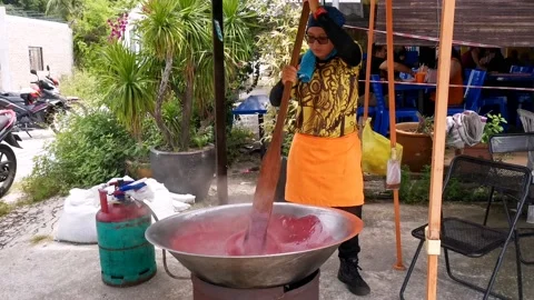 Dodol stirred deep inside the crater by a woman. Stock Footage 221083343