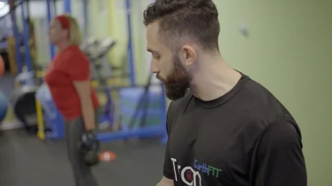 DOF side view of bearded trainer in gym Stock Footage 73186583