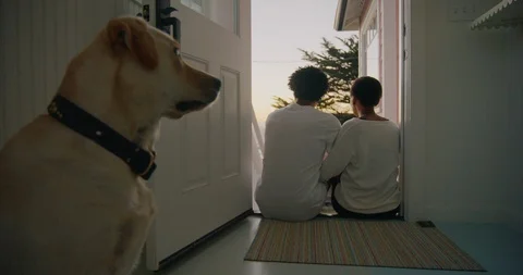 Dog sitting by the door while his owners sit looking at the view. Vidéo 93864244