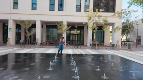 Doha, Qatar - 24 Oct. 2022: Worker cleaning fountin in Msheireb Downtown of D Stock Footage 325557681