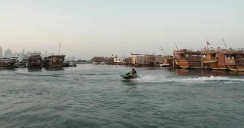Doha, Qatar - Man and boy riding jet ski in Doha harbour. Video stock 221872454