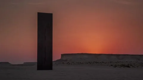 DOHA, QATAR - OCTOBER 25, 2024: A monolith stands against a stunning sunset on Stock Footage 289835540