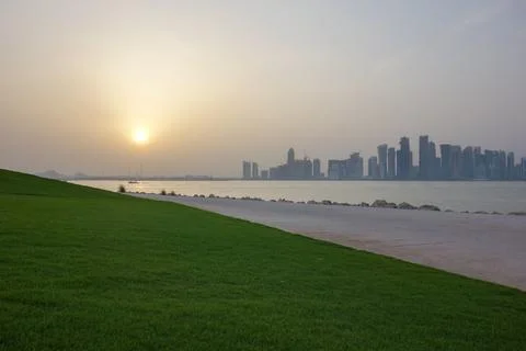 Doha, Qatar - sunset over Doha skyline with green park and waterfront along the  Stock Photos