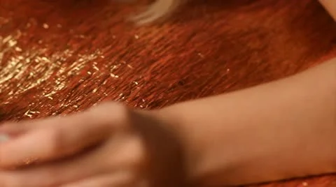 Doing her manicure with black nail polish on a gold background, slider motion Stock Footage 10583648